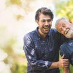 senior father with adult son in family concept banner background with copy space, elderly old man person are happy and enjoy with hipster son together by walking outdoor in nature